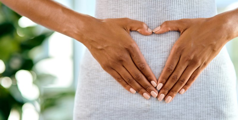 woman making heart shape over gut