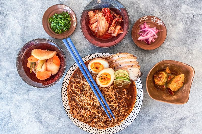ramen with bowls of kimchi