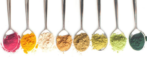 rainbow of superfood powders on spoons