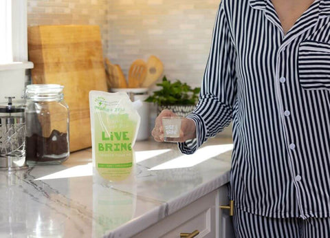 Woman in pjs drinking a shot of LiveBrine