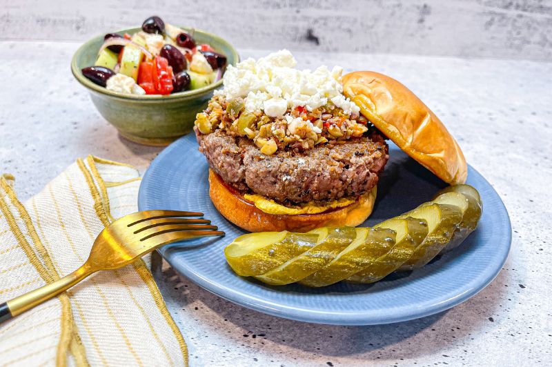 grilled burger with muffuletta olive mix and feta plus side salad