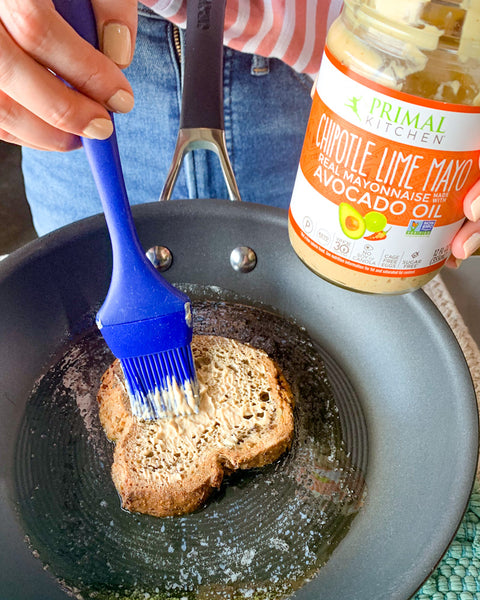Spreading Primal Kitchen Chipotle Lime Mayo on bread