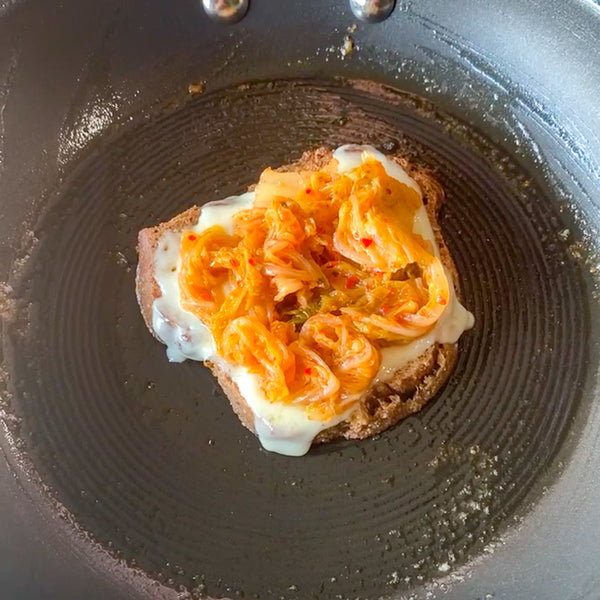 Placing Kimchi on top of melted cheese