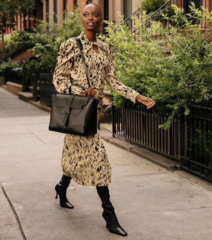 woman in printed dress with oversized designer bag