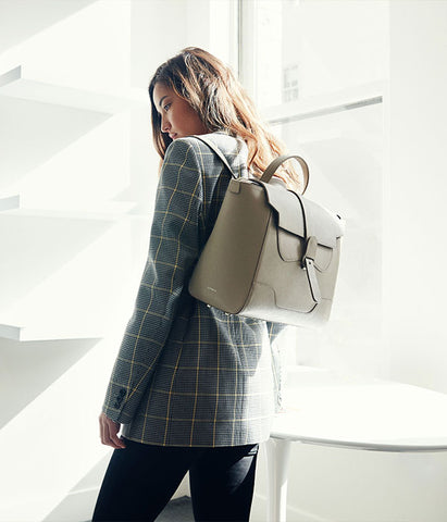 Model wearing blazer paired with maestra backpack