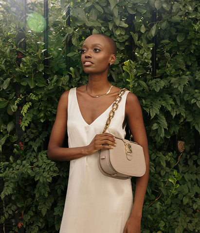 designer crossbody purse held by woman