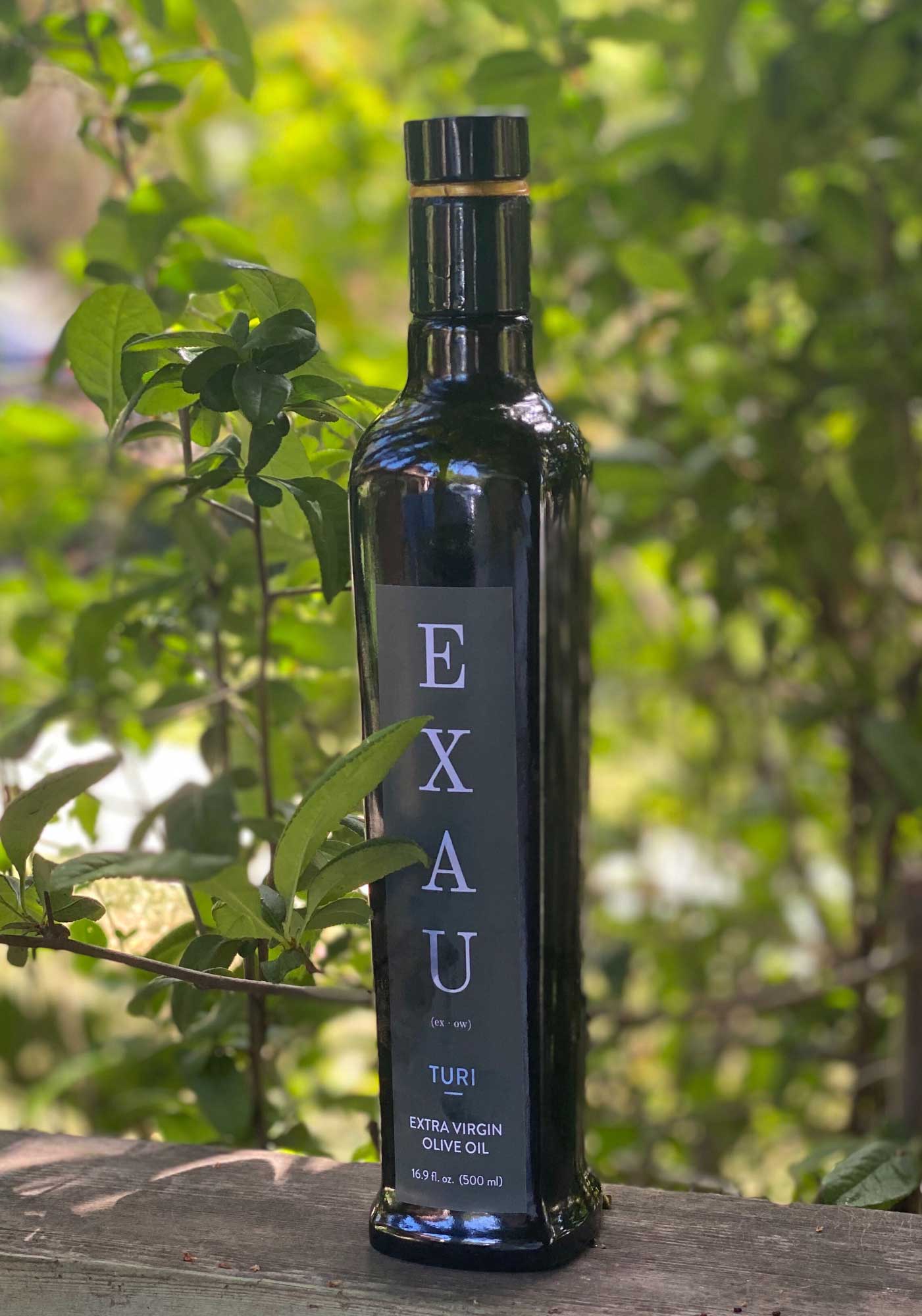 EXAU bottle in front of trees