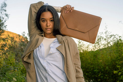 Woman holding tan laptop sleeve