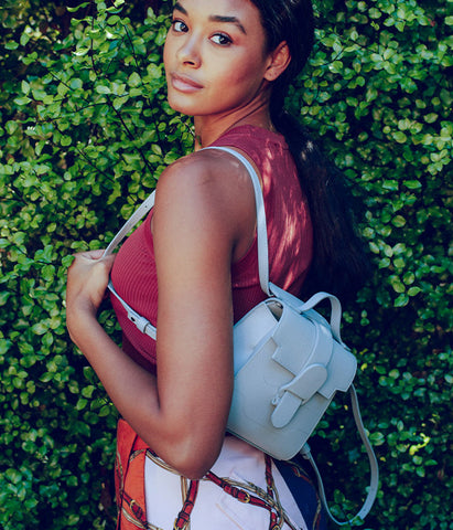 Model wearing mini backpack over shoulder