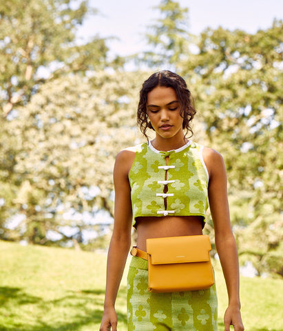 Woman in nature wearing belted yellow purse