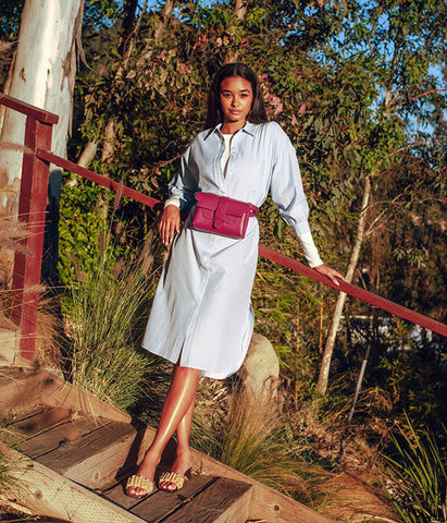 Model wearing casual shirtdress and belt bag