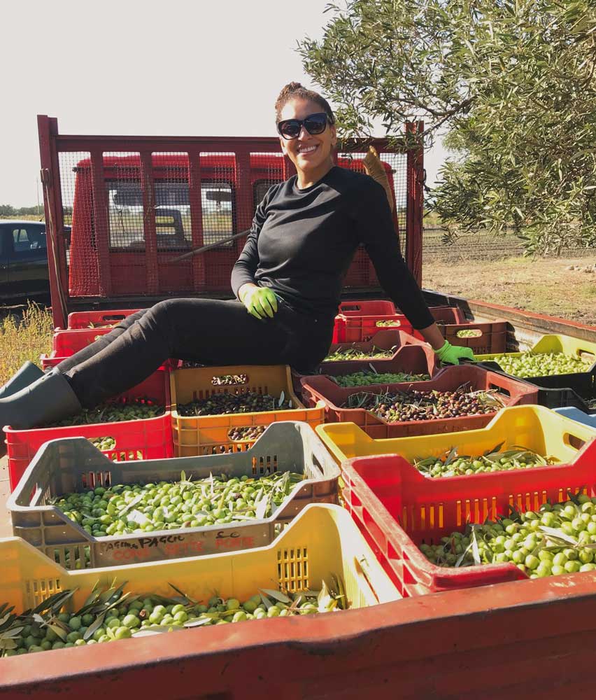 Skyler on top of a truck full of olives