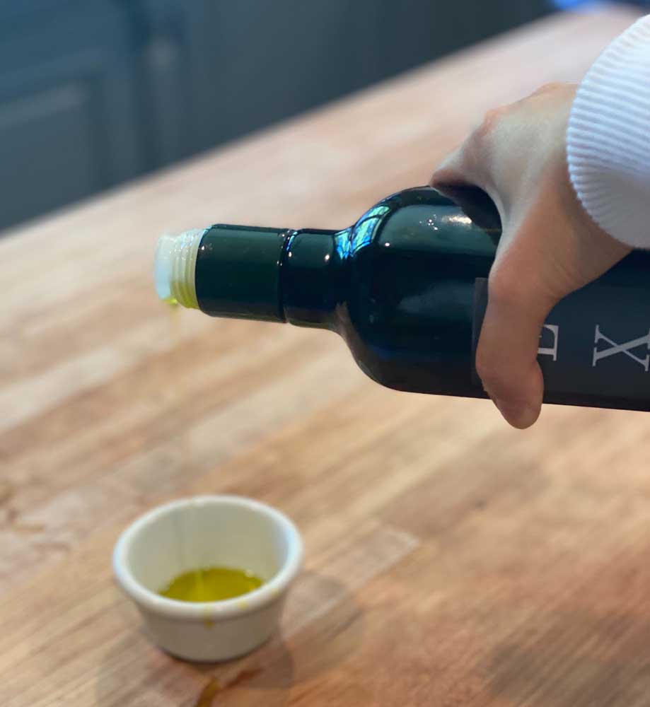 Olive oil being poured into a cup