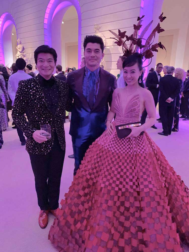 Coral and husband posing with Henry Golding