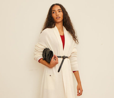 woman wearing white coat holding designer bag