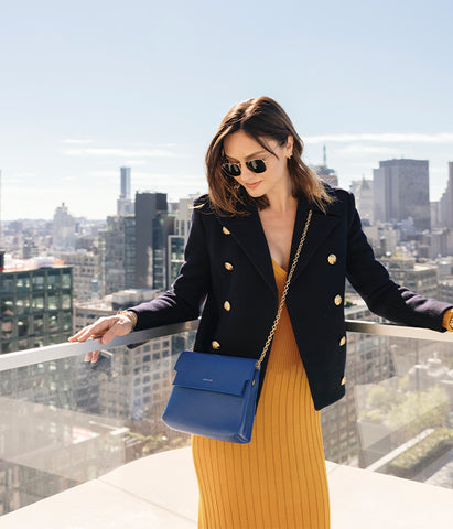 woman on rooftop wearing designer bag 