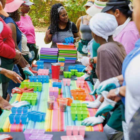 Ladies Standing Around a Table at Seed Starting Workshop With bright colored trays