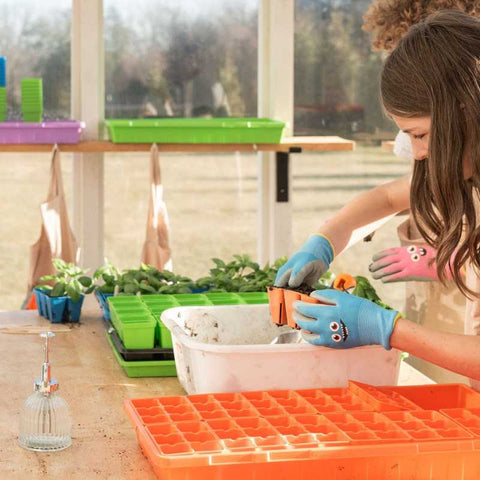 Girl and boy starting seeds in orange 6 cells