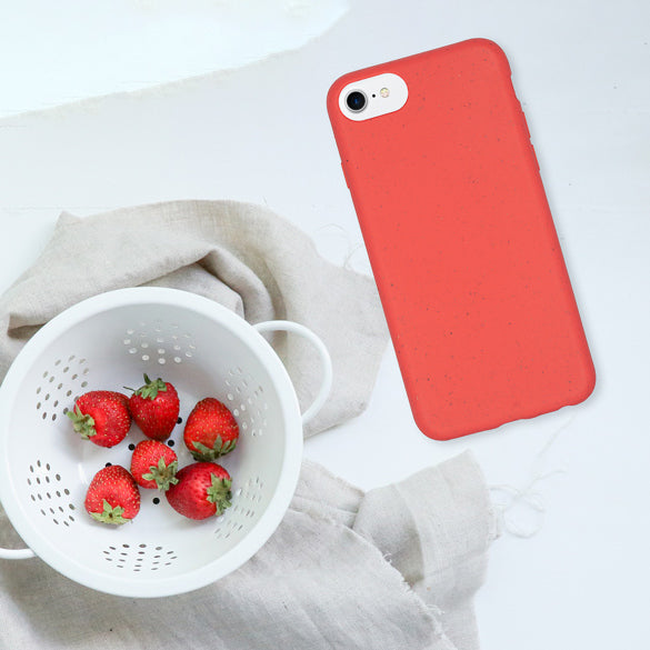 Flatlay aus roter, biologisch abbaubarer Handyhülle und Erdbeeren