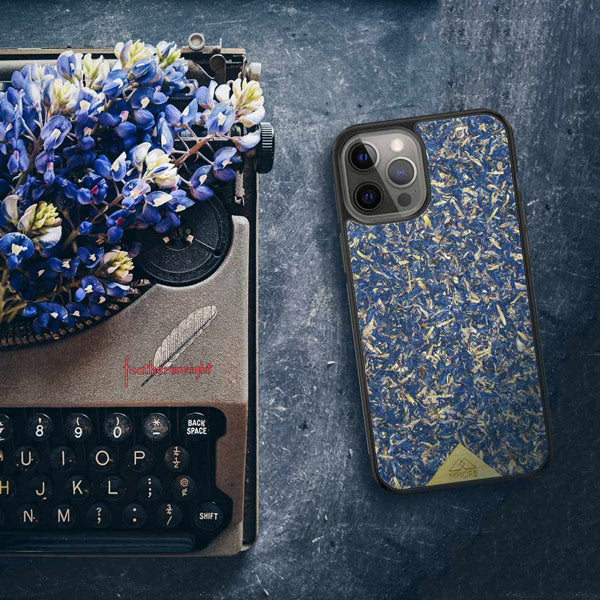 Organic Blue Cornflower Phone Case next to a Typerwriter