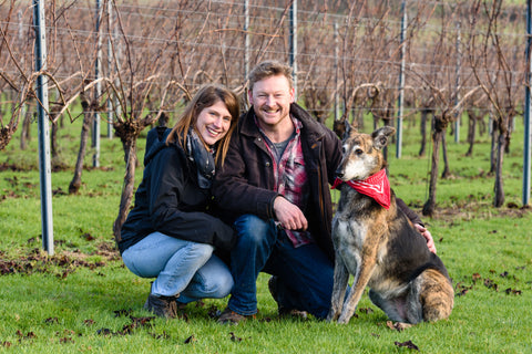 Ana and Dermot in the vines with their dog.