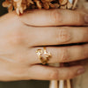 Guardian Angel bracelets in silver, gold, and rose gold stacked on burlap with a leafy background