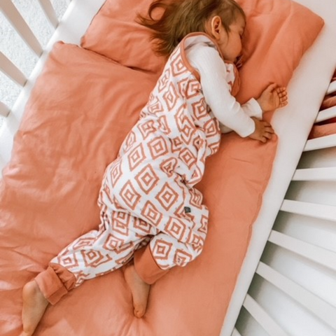 Kleinkind in Schlafsack mit Füßen