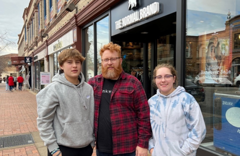 a man wearing The Normal Brand clothing with his two children.