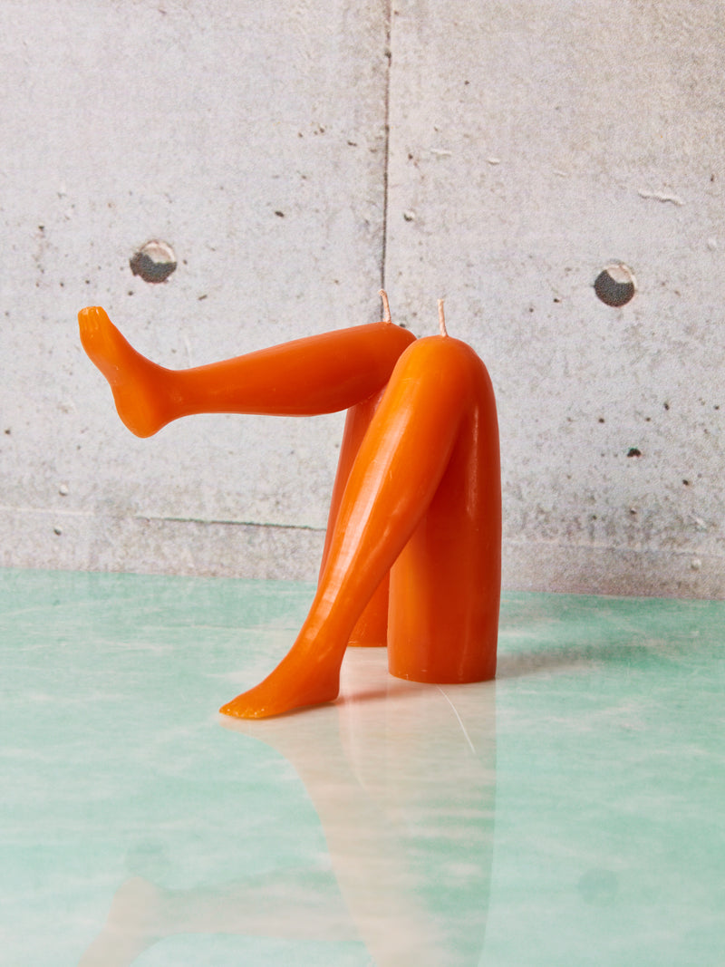 A pair of orange leg candles by Dada.