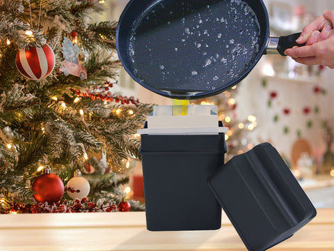 Image of non stick skillet pouring grease into black, rectangular container holding a grease bag, sitting on a counter. There is a Christmas tree and holiday decor in the background.