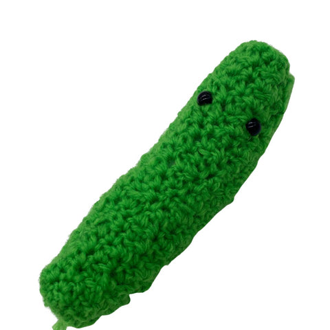 A pickle with little black eyes made out of green yarn