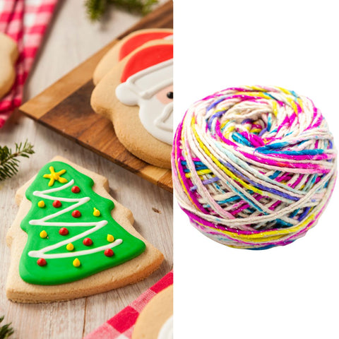 On the left, is an iced christmas tree sugar cookie, with a cake of white and rainbow sparkle worsted weight silk yarn on the right.