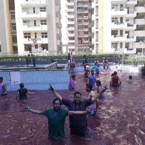  a crowd of festival goes wash themselves of the dye in large fountains or public pools