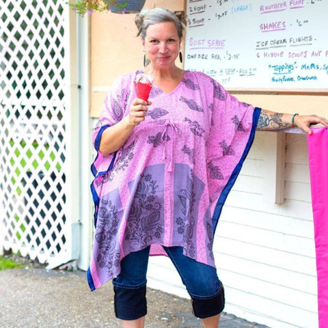 Model is eating ice cream cone wearing a pink short kaftan 