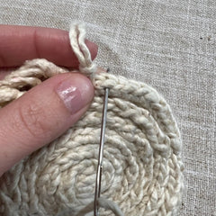 Pulling your 7" strand halfway through the outer edge of the coaster - Step 3