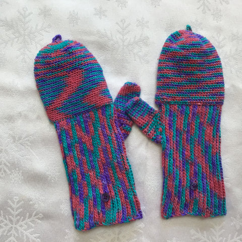 Finished multicolored crochet mittens on white tablecloth