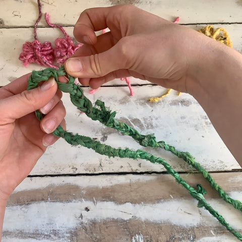 Picking a spot in the middle of the braid to pull the sari silk ribbon apart slightly.