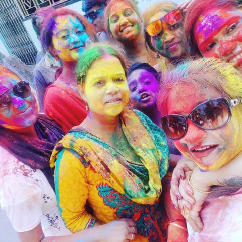 a group of artisans are covered in multi-colored powder.