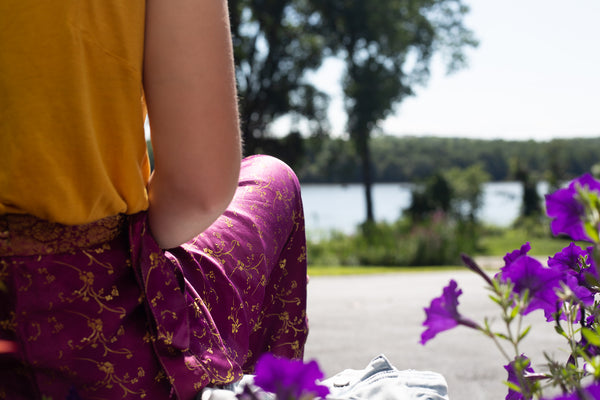 Close up of woman wearing sari wrap skirt while sitting on a public bench