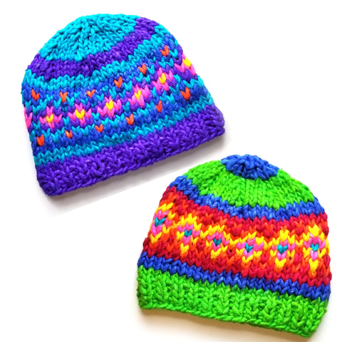 Two colorful beanies are laying on a white background.