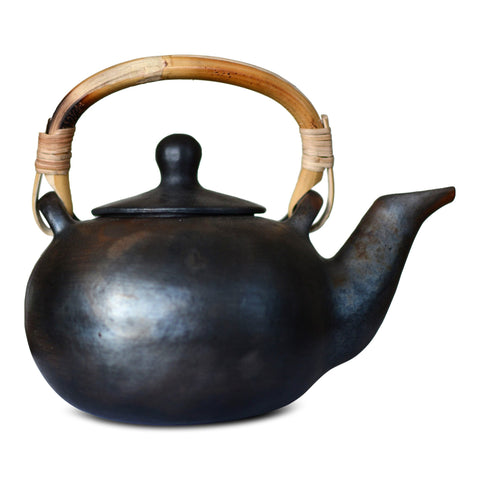 Black stone teapot with a wooden handle sitting on a white background