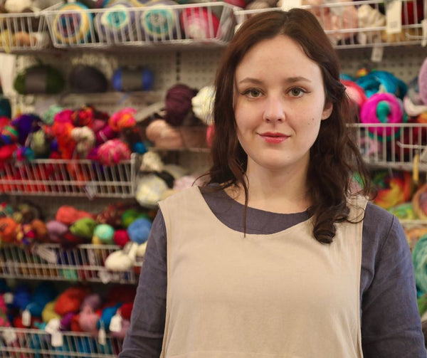 Brainstorm Art Supply founder, Jeannie Catmull, pictured in front of an array of colorful and sustainable yarn in the background