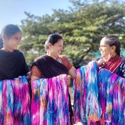 Three women holding freshly dyed Darn Good Yarn in India.