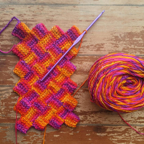 A skein of Darn Good Yarn and a crochet project in progress.