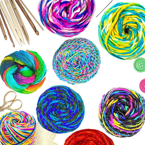 On a white background, multiple skeins of multicolored cakes of yarn and notions.