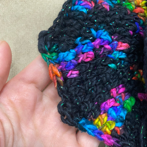  A closeup of the bat amigurumi wing, made out black and sparkle rainbow worsted weight yarn.