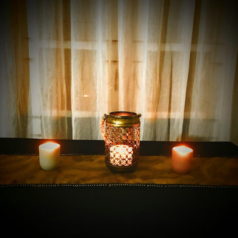 Final sari fabric table runner with candles lit on top.