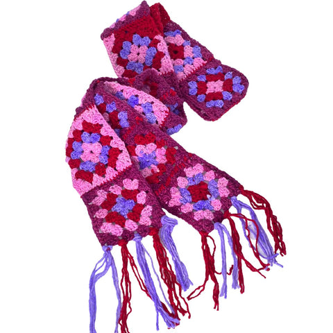 A scarf made of red, pink, magenta, and lavender worsted weight granny squares.