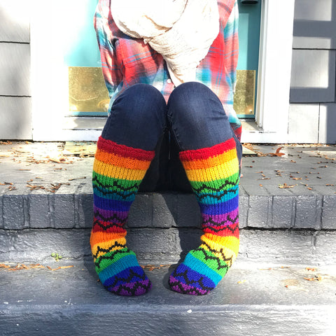 Close up of woman wearing fleece lined wool socks and sitting on a gray brick step