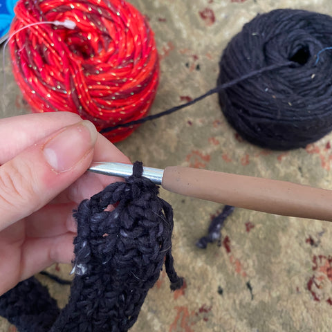 The brown crochet hook is attached to the end of the headband, ready to make the chains to create the straps.